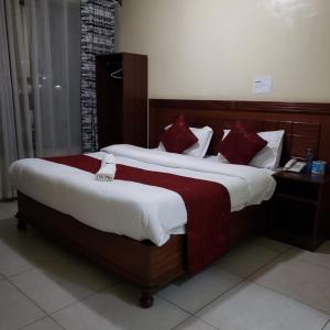 Un dormitorio con dos camas con almohadas rojas. en Capital Comfort Hotel, en Nairobi