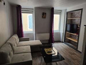 a living room with a couch and a tv at duplex centre ville in Privas