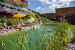 un grupo de personas nadando en una piscina en Bachgut, das Resort am Berg - Stammhaus Winter, en Saalbach Hinterglemm