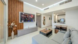 a living room with a couch and a tv at Breathtaking Sea View Retreat by Hala Homes in Ras al Khaimah
