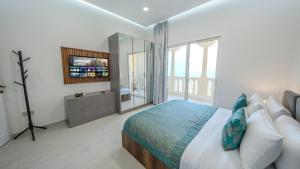 a bedroom with a bed and a large window at Breathtaking Sea View Retreat by Hala Homes in Ras al Khaimah +14 photos