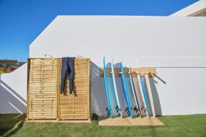 a bunch of skis are leaning against a wall at Wander Surf House in Santa Cruz +93 photos