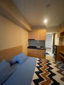 een slaapkamer met een groot bed en een keuken bij Apartemen Anderson 28 Pakuwon mall Luxury Studio Apartment Connecting Mall, Pool & City View in Surabaya