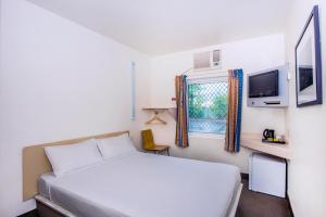 a small bedroom with a bed and a window at ibis Budget Coffs Harbour in Coffs Harbour