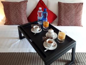 a black coffee table with two cups and drinks on a bed at La Consolata in Aosta