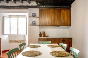 a dining room with three tables and green chairs at Staymoz in Estremoz