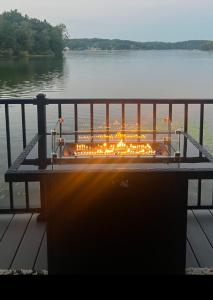 a fire pit sitting on a dock next to a body of water at Off the Hook in Newaygo
