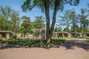 un parque con un árbol y un parque infantil en Bospark Ede, en Ede
