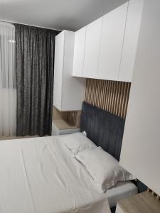 a bedroom with a white bed and white cabinets at LCB Apartments Universitate Suceava A59 in Suceava +5 photos