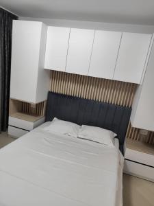 a bedroom with a large bed with white sheets at LCB Apartments Universitate Suceava A59 in Suceava