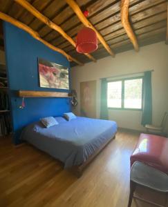 Un dormitorio con una cama y una pared azul. en House of culture and meetings, en Vaqueros