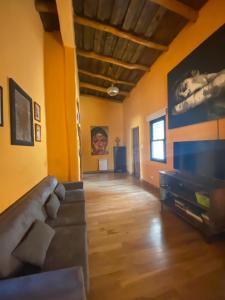 sala de estar con paredes amarillas y sofá en House of culture and meetings, en Vaqueros
