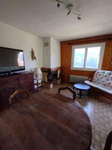 a living room with a wooden table and a couch at Les Chrysalis - Nature, Lac, Montagnes & Ski 10'min in Les Villards-sur-Thônes