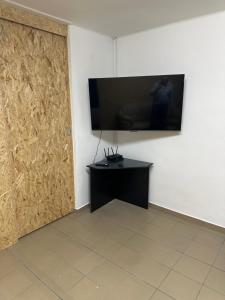 a room with a television on a wall with a door at Hostel TV in Trebišov