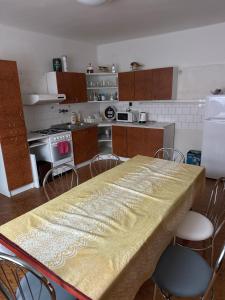 a kitchen with a table and chairs and a kitchen with at Hostel TV in Trebišov