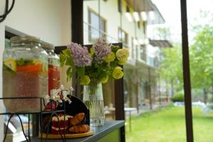 a table with a vase filled with flowers and cookies at Restland Dilijan Family Hotel in Dilijan