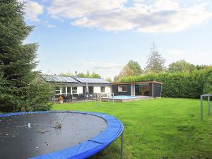 a house with a trampoline in a yard at 10 person holiday home in Væggerløse in Marielyst