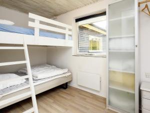 a bunk bed room with two bunk beds and a window at 10 person holiday home in Væggerløse in Marielyst