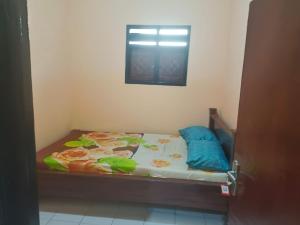 a small bed in a room with a window at Oseng Pesona House in Ketapang
