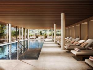 a swimming pool with lounge chairs and a pool house at Hotel Oberforsthof in Sankt Johann im Pongau