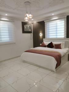 a bedroom with a large bed in a white room at إيوان الفخامة in Al Madinah
