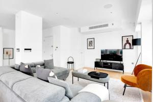a white living room with a couch and a tv at Blueground Fitzrovia spa nr Oxford St LON-178 in London