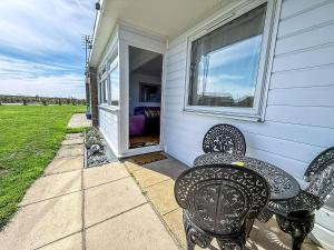 two chairs sitting on the porch of a house at Stunning Chalet In The Charming Seaside Village Of Scratby, Norfolk Ref 51017S in Great Yarmouth
