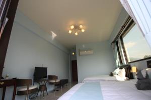a hotel room with a bed and a window at Xinyue B&B in Fenglin