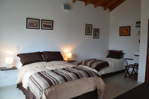 2 camas en una habitación con paredes blancas en El Chalten Aparts en El Chaltén