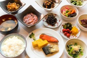 Hotel Resol Sapporo Nakajima Koen في سابورو: طاولة مع أطباق بأنواع مختلفة من الطعام