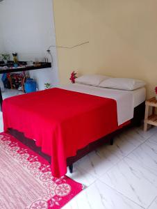 a bedroom with a bed with a red blanket on it at Luxury caiçara house in Paraty in Paraty