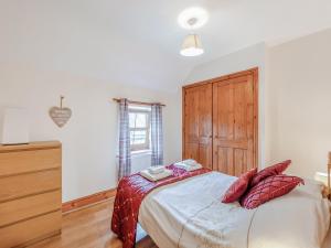 ein Schlafzimmer mit einem großen Bett mit roten Kissen in der Unterkunft The Cottage - 28645 in Alston + 7 Fotos