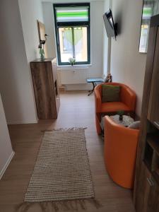 a living room with an orange couch and a window at Fridolin in Reichenbach im Vogtland