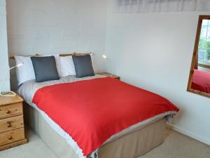 a bedroom with a bed with a red blanket at Towan View in Newquay