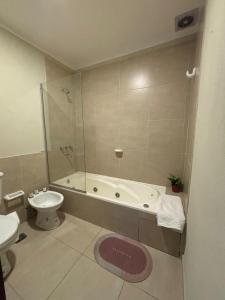 a bathroom with a tub and a toilet and a sink at Las Bahuinias in San Fernando del Valle de Catamarca