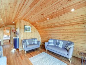 a living room with two chairs and a television at Primrose - Uk42358 in Saint Harmon
