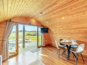 a dining room with a table and chairs and a balcony at Primrose - Uk42358 in Saint Harmon