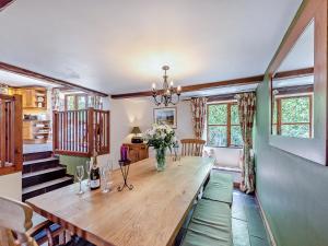 a dining room with a wooden table and some windows at The Old Roundhouse in Hartland