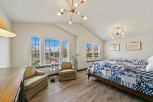 a bedroom with a bed and a chair and windows at Boise Hills Luxurious Retreat in Boise