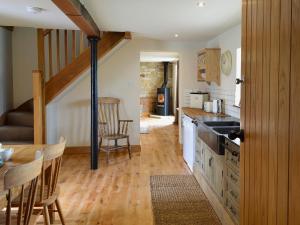 a kitchen with a table and chairs in a room at Mullins Cottage in Gristhorpe