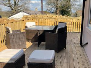 a patio with a table and chairs on a deck at The Old Kitchen -Uk32062 in Burwarton