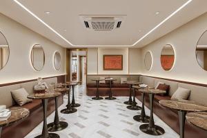 un restaurante con mesas, sillas y espejos en Grand Mays Inn Hotel & Spa, en Ho Chi Minh