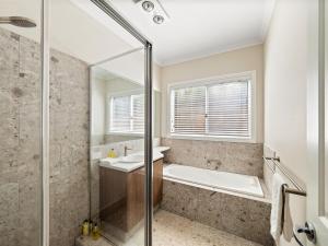 a bathroom with a shower and a tub and a sink at Flinders View Beach House 2Bed 2Bath in Augusta