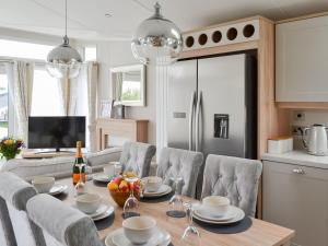 Una cocina y un comedor con mesa y sillas. en Reel Paradise - Uk37723, en Ingoldmells