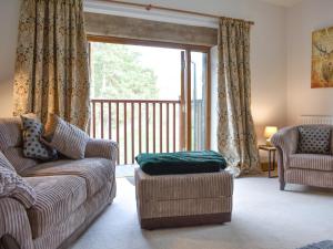 a living room with a couch and a large window at Quarry Cottage in Penrith