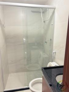 a bathroom with a glass shower with a toilet at Paradise Flat 412 in Nossa Senhora do Livramento