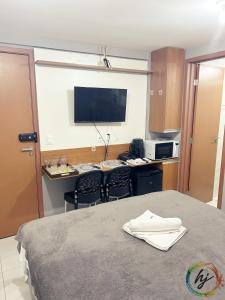 a hotel room with a bed and a tv on the wall at Paradise Flat 412 in Nossa Senhora do Livramento