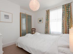 ein Schlafzimmer mit einem weißen Bett und einem Fenster in der Unterkunft Quays Cottage in Salcombe