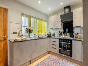 a kitchen with stainless steel appliances and a window at Merriman Lodge in Street
