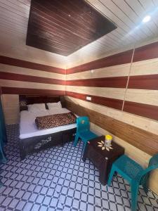 a room with a bed and a table in it at Omji - Susharda Sewa Sansthan Jankichatti Near Yatra Starting Point, Yamunotri in Kharsālī